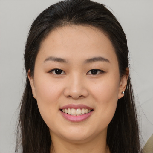 Joyful asian young-adult female with long  brown hair and brown eyes