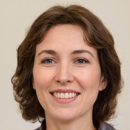 Joyful white adult female with medium  brown hair and green eyes