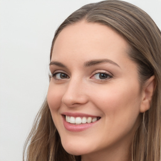 Joyful white young-adult female with long  brown hair and grey eyes