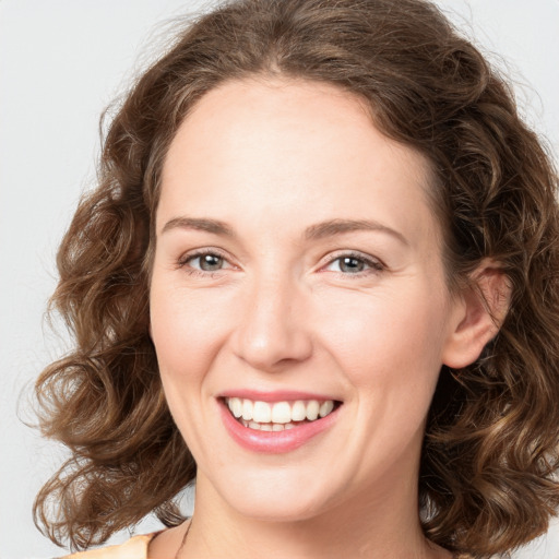 Joyful white young-adult female with medium  brown hair and green eyes