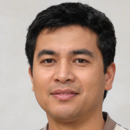 Joyful asian young-adult male with short  black hair and brown eyes