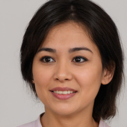 Joyful asian young-adult female with medium  brown hair and brown eyes