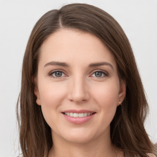 Joyful white young-adult female with long  brown hair and grey eyes