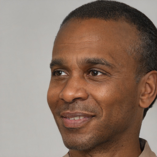 Joyful black adult male with short  brown hair and brown eyes