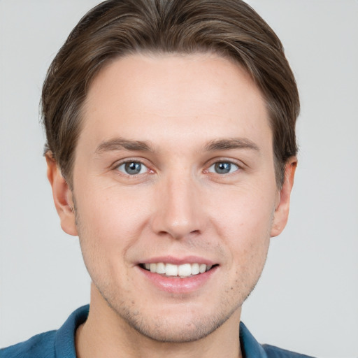 Joyful white young-adult male with short  brown hair and grey eyes