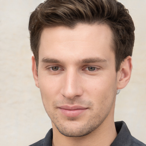 Joyful white young-adult male with short  brown hair and grey eyes