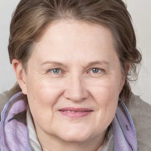 Joyful white adult female with medium  brown hair and blue eyes