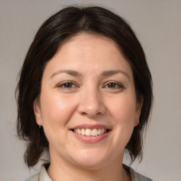 Joyful white adult female with medium  brown hair and brown eyes