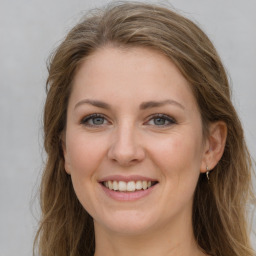 Joyful white young-adult female with long  brown hair and grey eyes