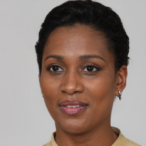 Joyful black young-adult female with short  black hair and brown eyes