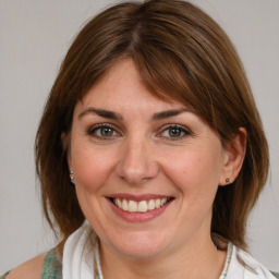 Joyful white young-adult female with medium  brown hair and blue eyes