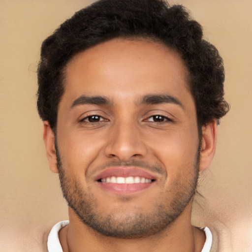 Joyful latino young-adult male with short  brown hair and brown eyes