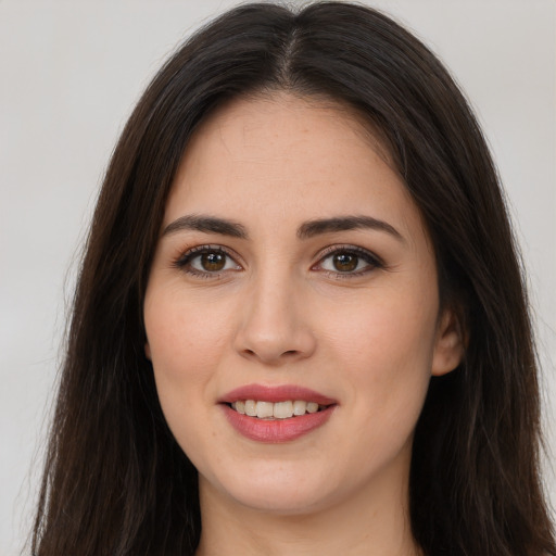 Joyful white young-adult female with long  brown hair and brown eyes