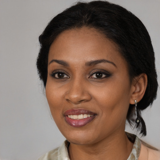 Joyful black adult female with medium  brown hair and brown eyes