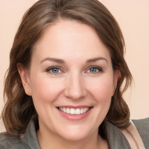 Joyful white young-adult female with medium  brown hair and grey eyes