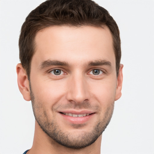 Joyful white young-adult male with short  brown hair and grey eyes