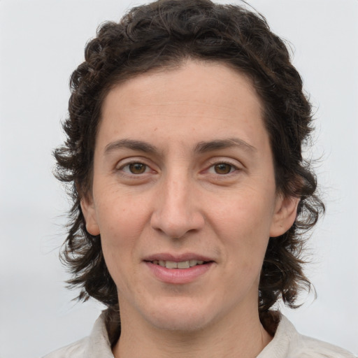 Joyful white adult female with medium  brown hair and green eyes