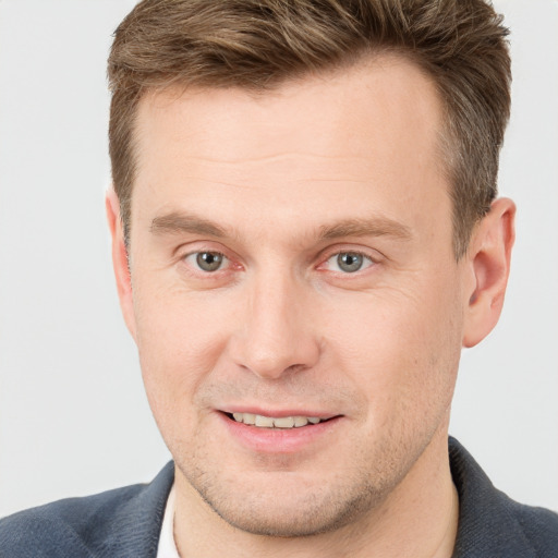 Joyful white young-adult male with short  brown hair and grey eyes