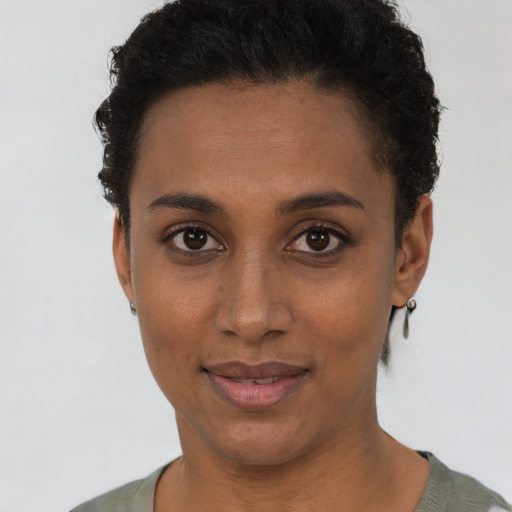 Joyful black young-adult female with short  brown hair and brown eyes