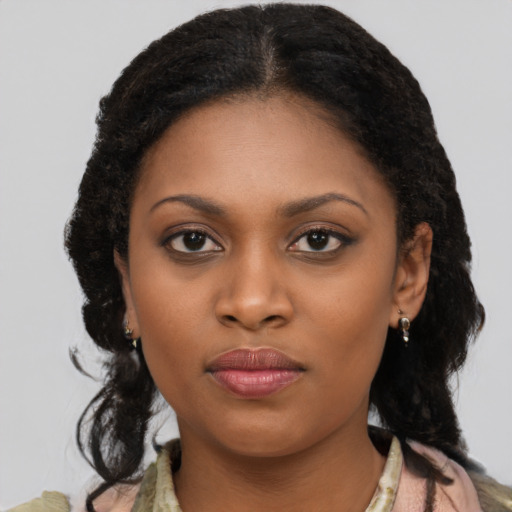 Joyful black young-adult female with long  black hair and brown eyes