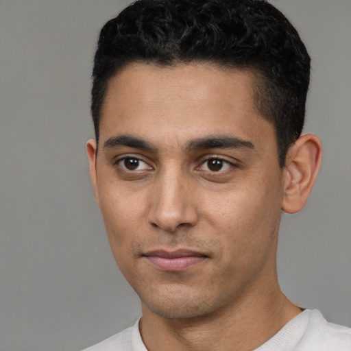 Joyful latino young-adult male with short  black hair and brown eyes