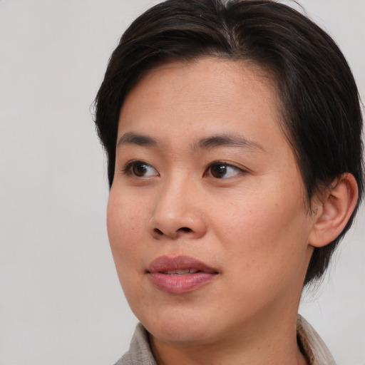 Joyful asian young-adult female with short  brown hair and brown eyes