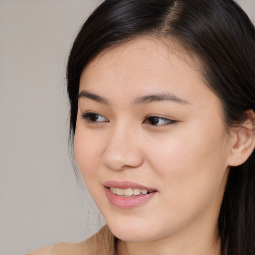 Joyful asian young-adult female with long  brown hair and brown eyes
