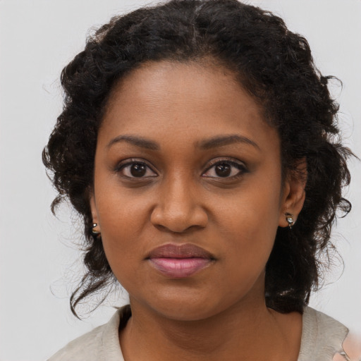 Joyful black young-adult female with long  brown hair and brown eyes