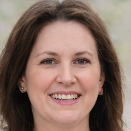 Joyful white adult female with long  brown hair and brown eyes