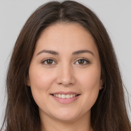 Joyful white young-adult female with long  brown hair and brown eyes