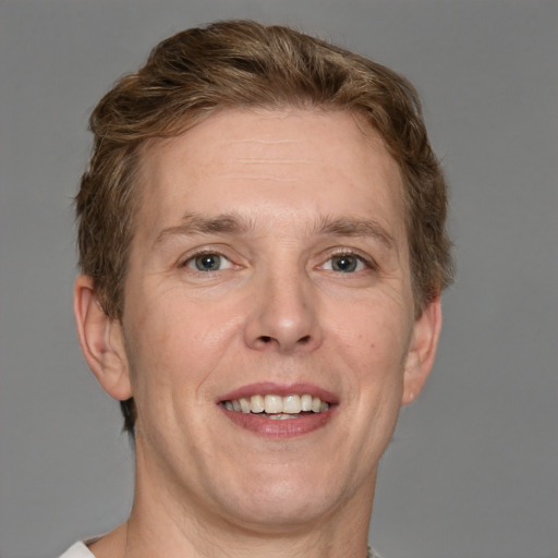 Joyful white adult male with short  brown hair and grey eyes