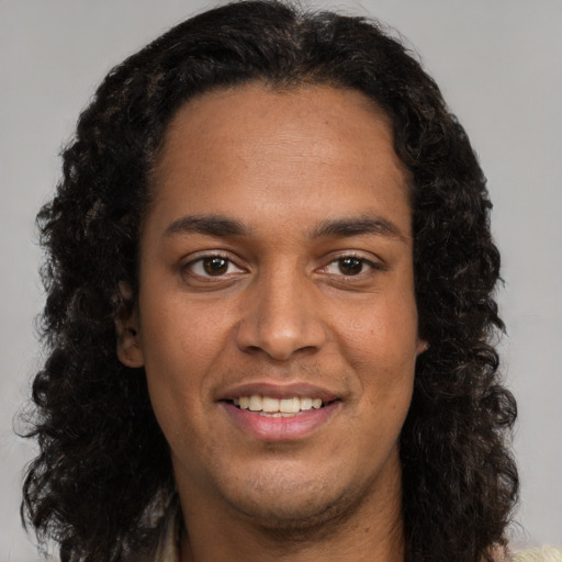 Joyful black young-adult male with long  brown hair and brown eyes