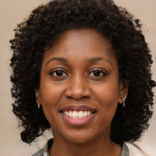 Joyful black young-adult female with medium  brown hair and brown eyes