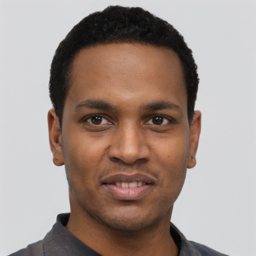 Joyful black young-adult male with short  black hair and brown eyes