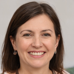 Joyful white adult female with long  brown hair and brown eyes