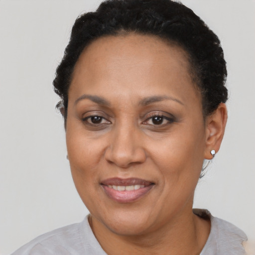 Joyful latino adult female with short  brown hair and brown eyes