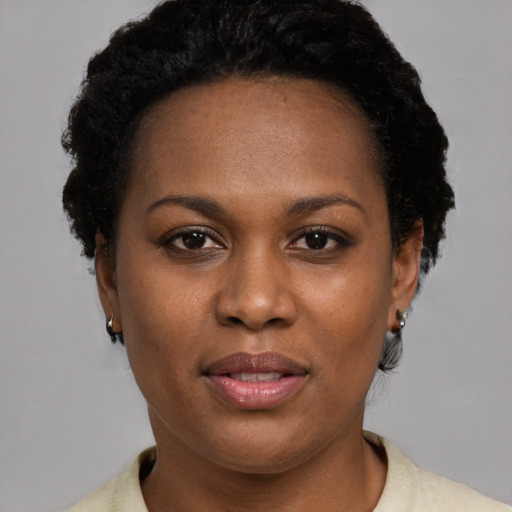 Joyful black young-adult female with short  brown hair and brown eyes