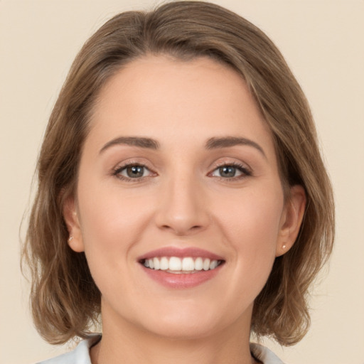 Joyful white young-adult female with medium  brown hair and green eyes