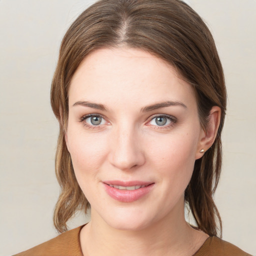 Joyful white young-adult female with medium  brown hair and grey eyes