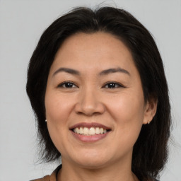 Joyful asian adult female with medium  brown hair and brown eyes