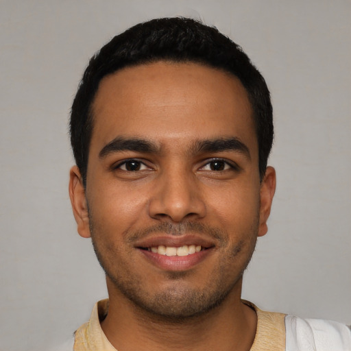 Joyful latino young-adult male with short  black hair and brown eyes