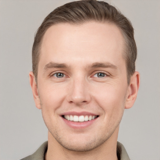 Joyful white young-adult male with short  brown hair and grey eyes