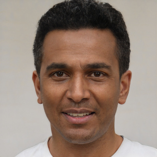Joyful latino adult male with short  black hair and brown eyes
