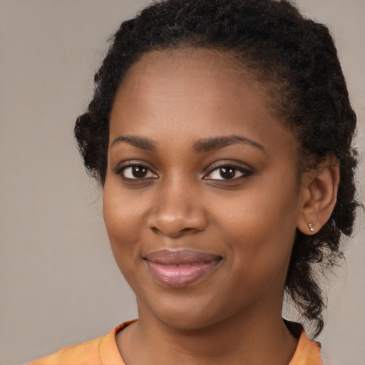 Joyful black young-adult female with medium  black hair and brown eyes
