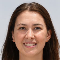 Joyful white adult female with long  brown hair and grey eyes