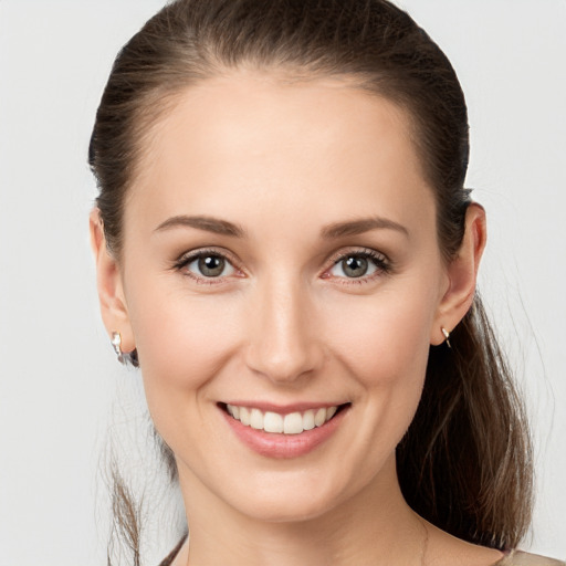 Joyful white young-adult female with medium  brown hair and grey eyes