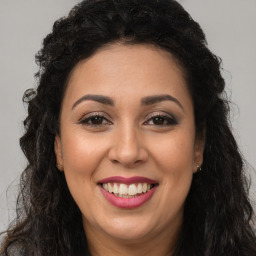 Joyful latino young-adult female with long  brown hair and brown eyes