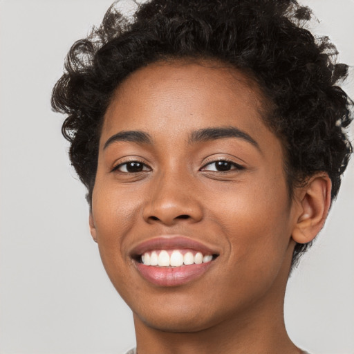 Joyful black young-adult female with short  black hair and brown eyes