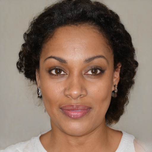 Joyful black adult female with medium  brown hair and brown eyes