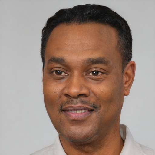 Joyful black adult male with short  black hair and brown eyes